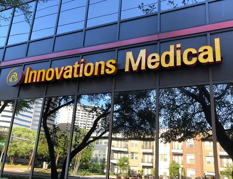 Innovations Medical building in Dallas – black exterior with large windows and yellow sign visible from Coit Rd.